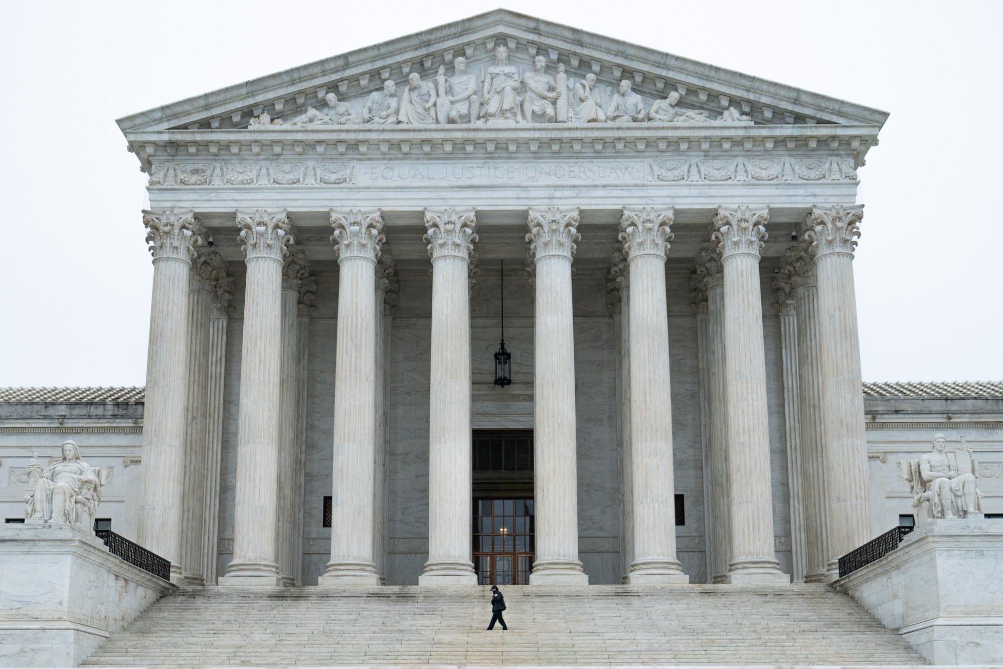 A security guard on the steps of the US Supreme Court in Washington, DC, US, on Friday, Feb. 20, 2026. The US Supreme Court struck down President Donald Trump's sweeping global tariffs, undercutting his signature economic policy and delivering his biggest legal defeat since he returned to the White House. Photographer: Annabelle Gordon/Bloomberg