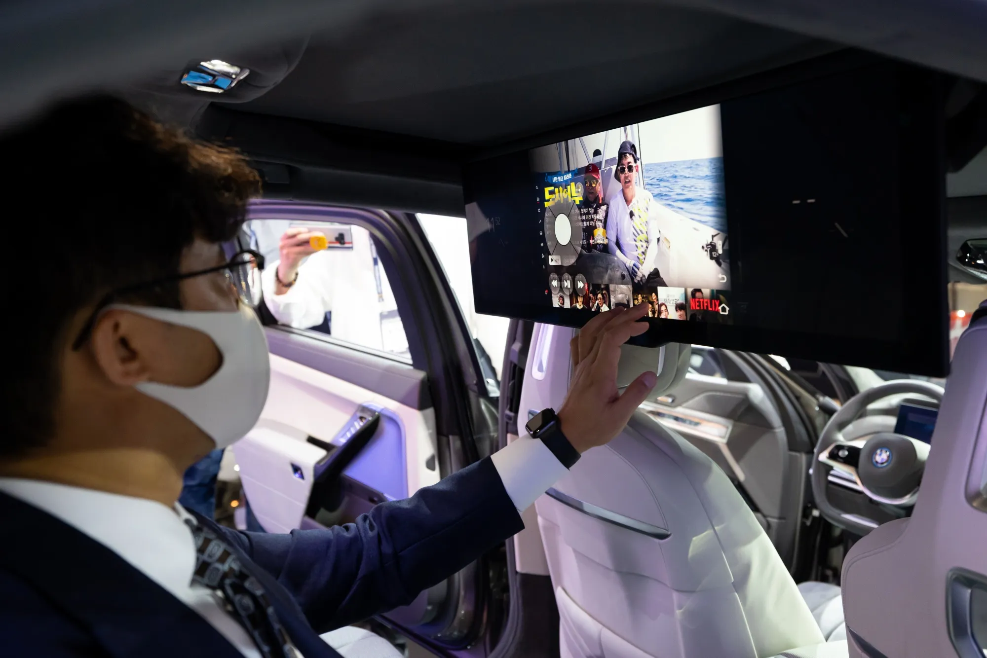 A&nbsp;Busan International Motor Show attendee in a BMW i7 electric vehicle.