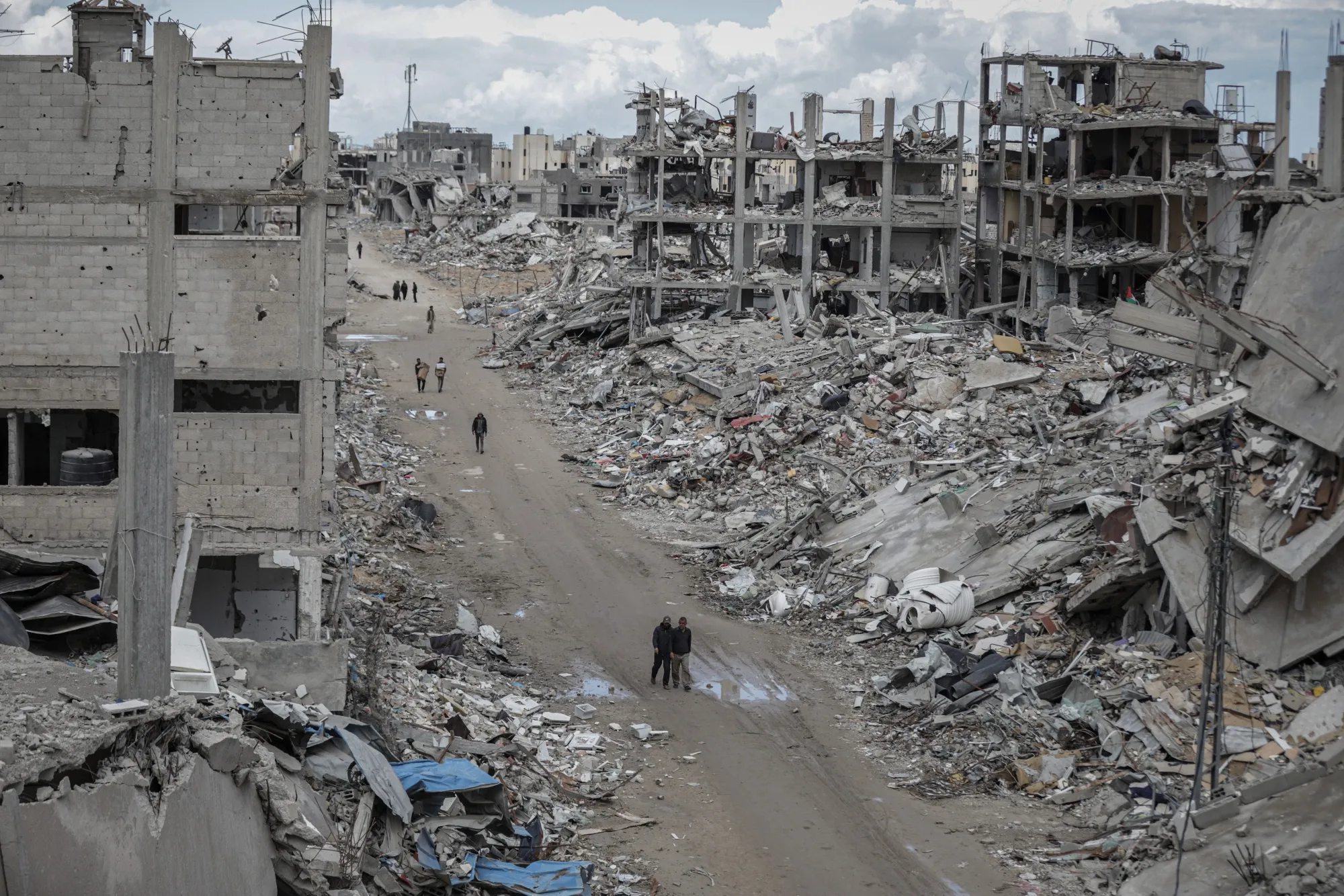 Palestinians walk past destroyed buildings&nbsp;in Rafah, southern Gaza, on Jan. 24.