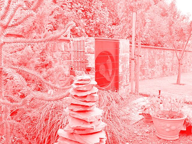 A heat pump sits in a landscaped garden