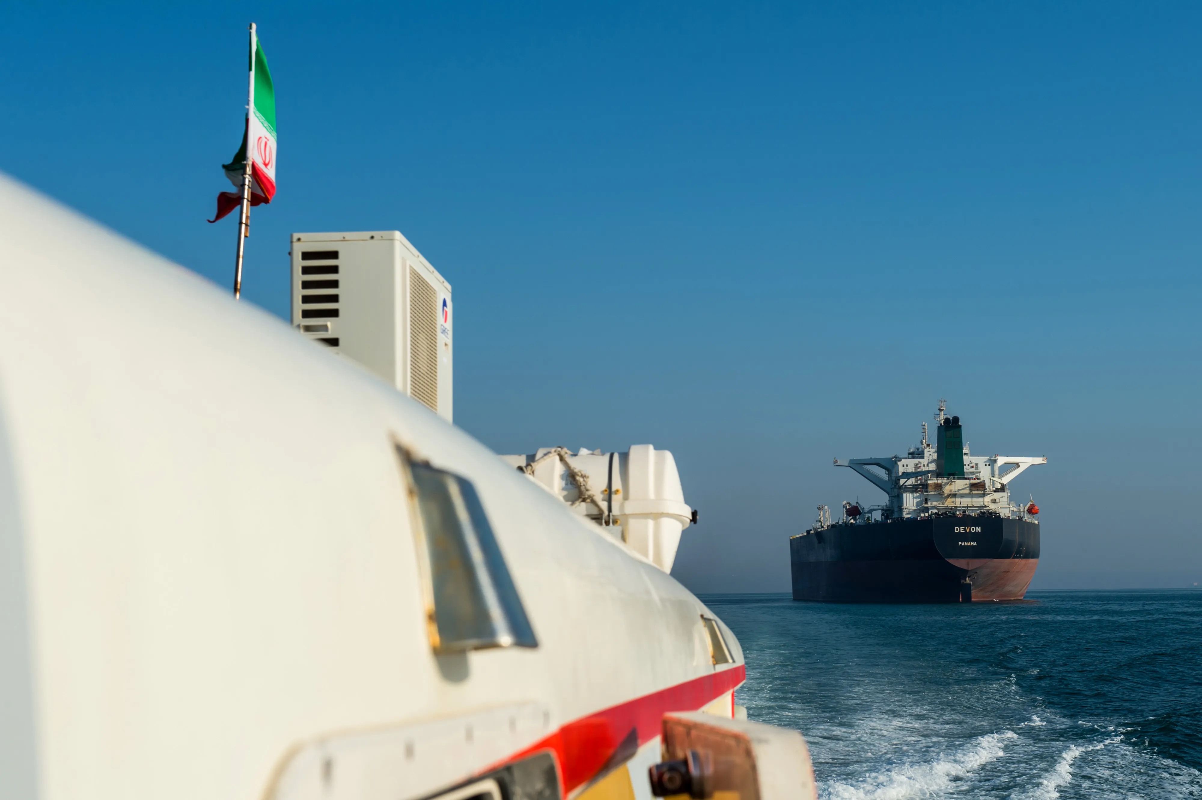A support vessel maneuvers near a crude oil tanker as it sails through the Persian Gulf toward&nbsp;Kharg Island.