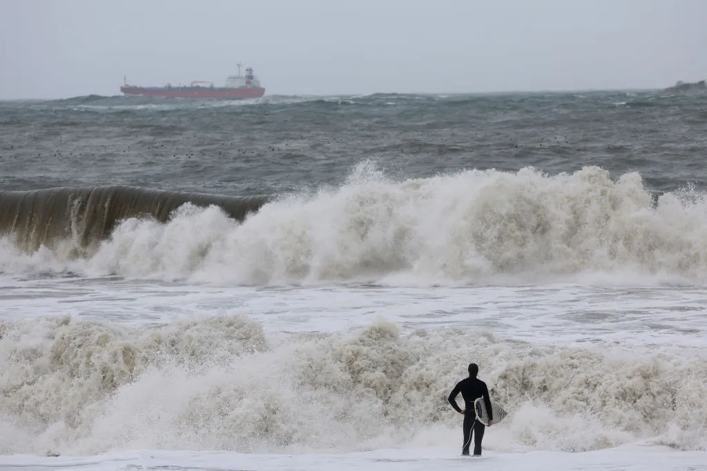 A surfer looks out at rough surf as a storm comes in Rodeo Beach on Jan.&nbsp;7.