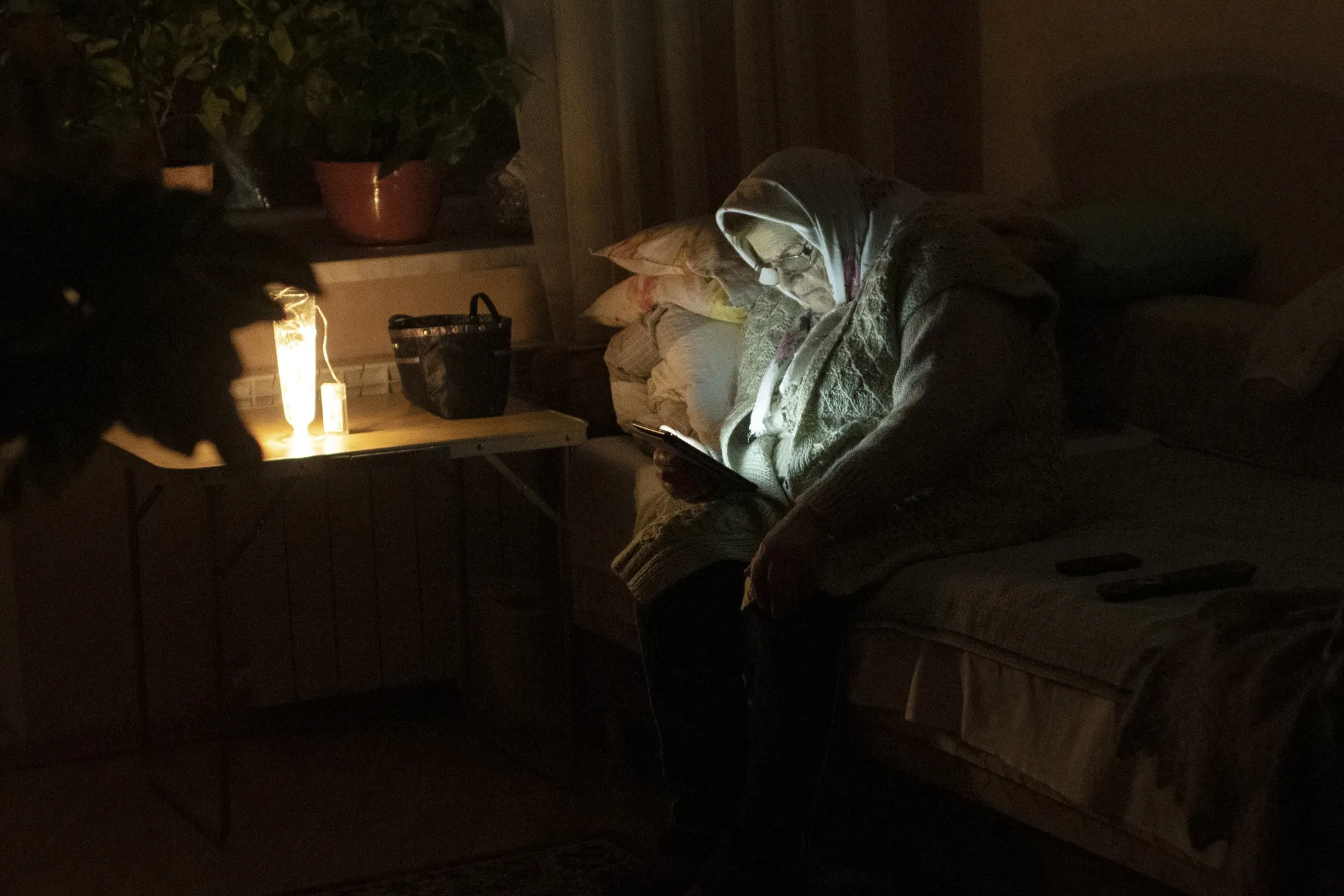 A Kyivan uses a battery powered light to read during a blackout.&nbsp;