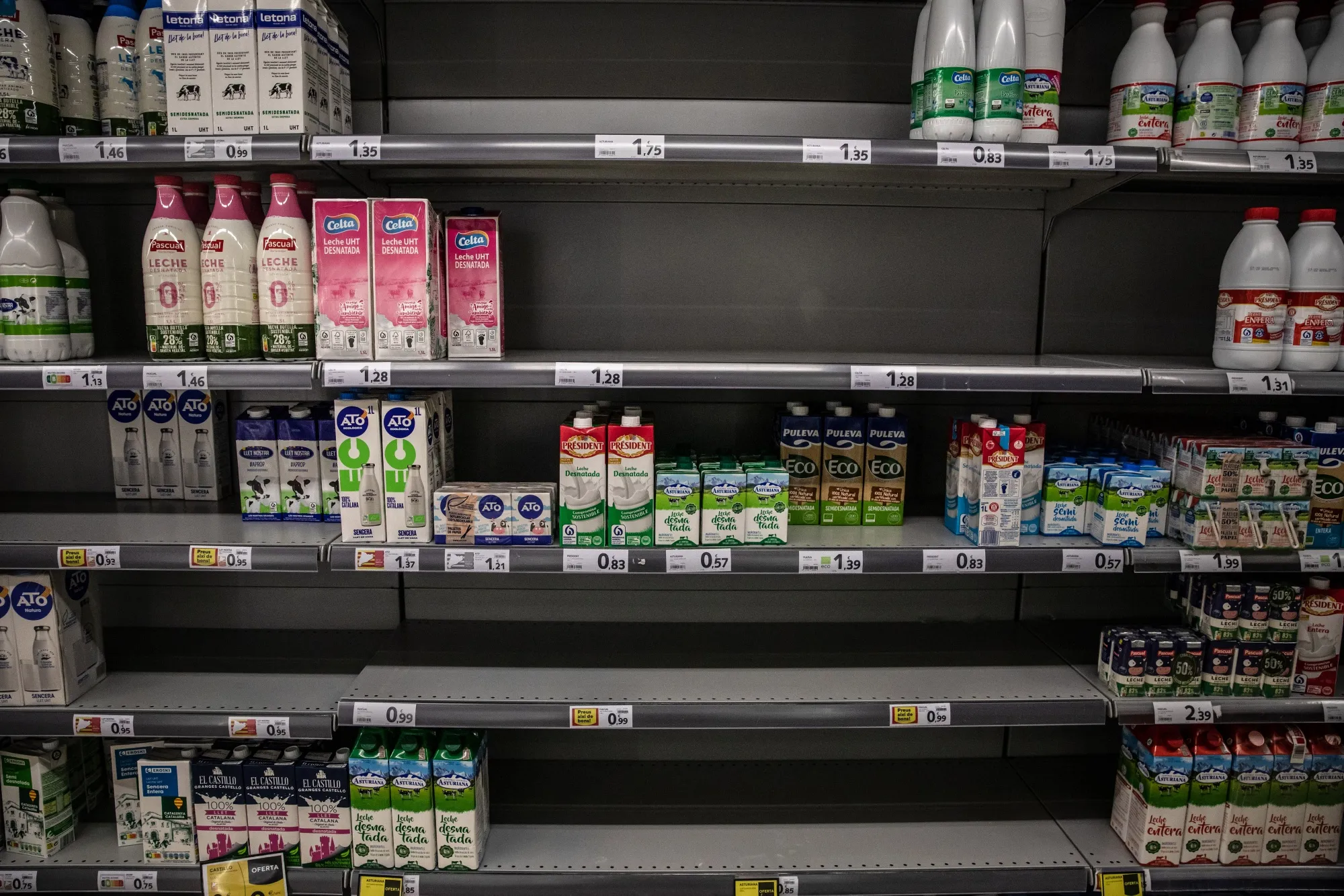Empty shelves in the long-life milk section inside a supermarket in Barcelona, Spain.