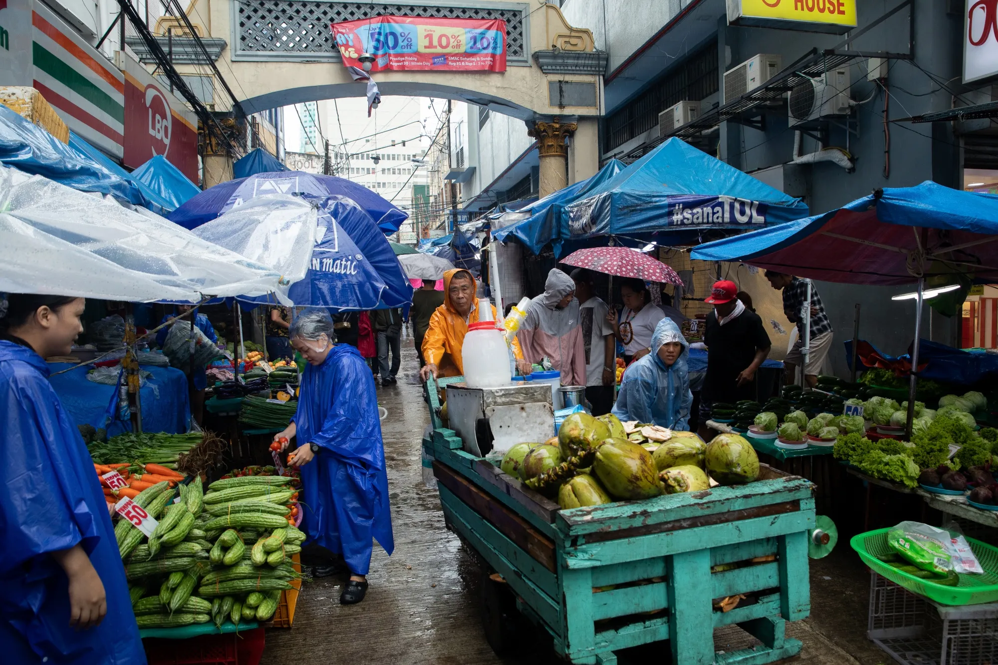 A coconut vendor pushes a cart through the Quiapo Market in Manila.