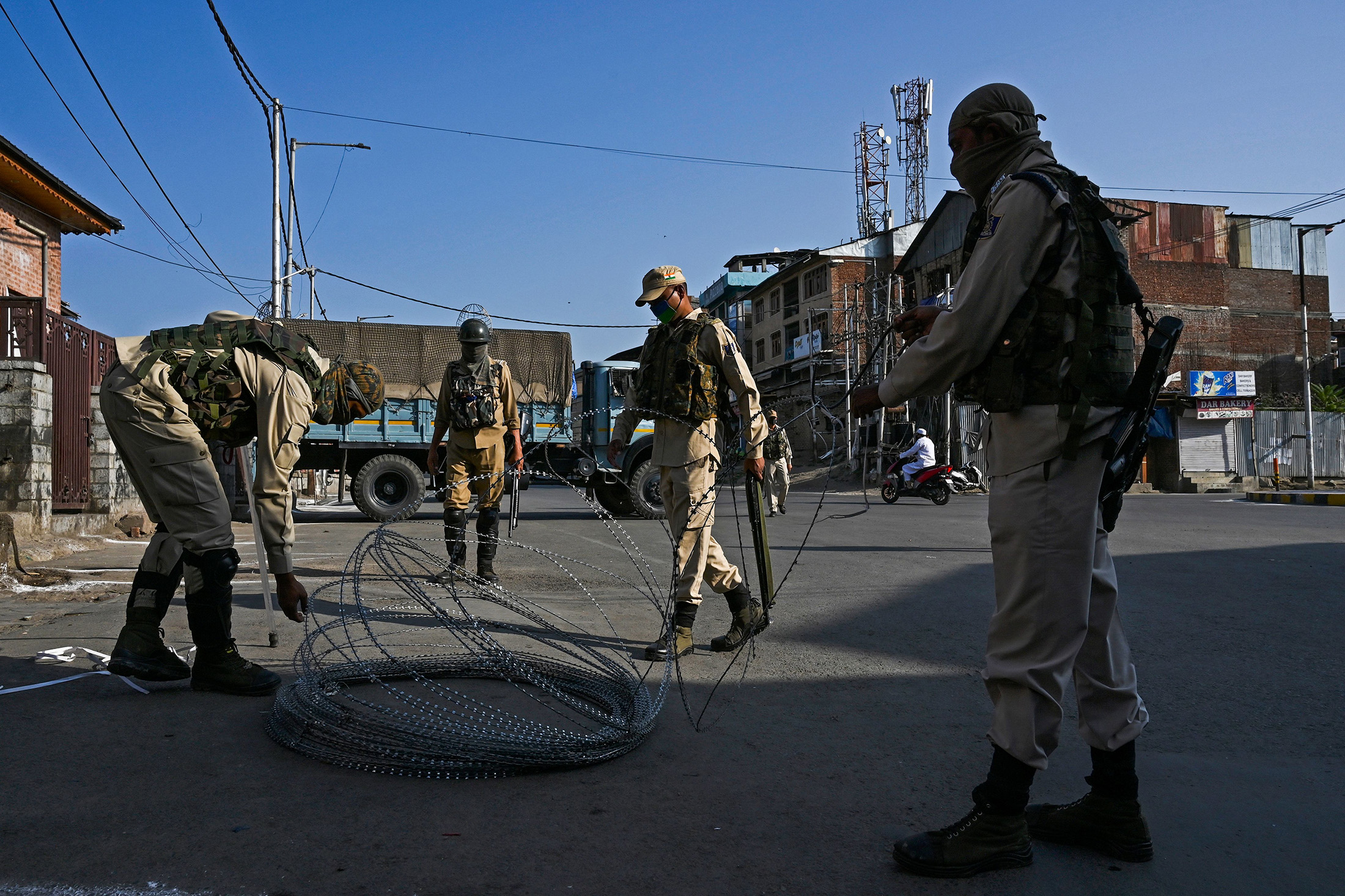 Paramilitary soldiers set up a roll of barbed wire at a checkpoint during curfew in Srinagar on August 4.