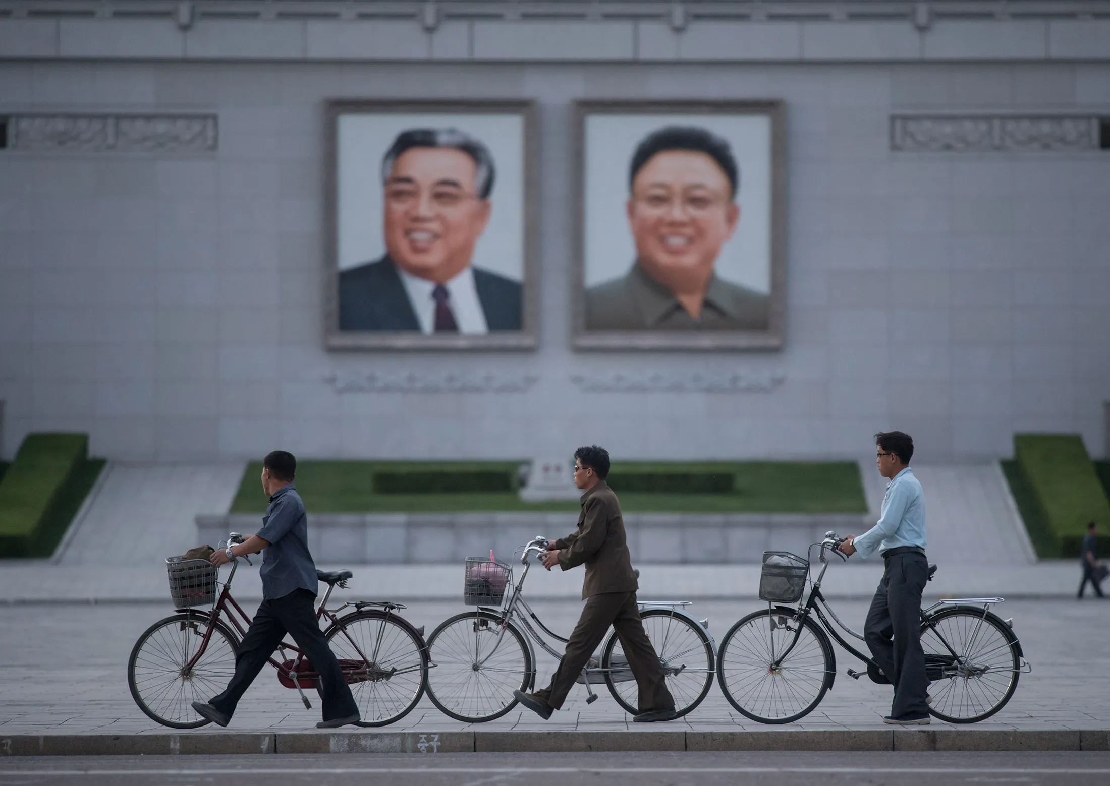 Men push their bicycles&nbsp;on Kim Il Sung square in Pyongyang.&nbsp;