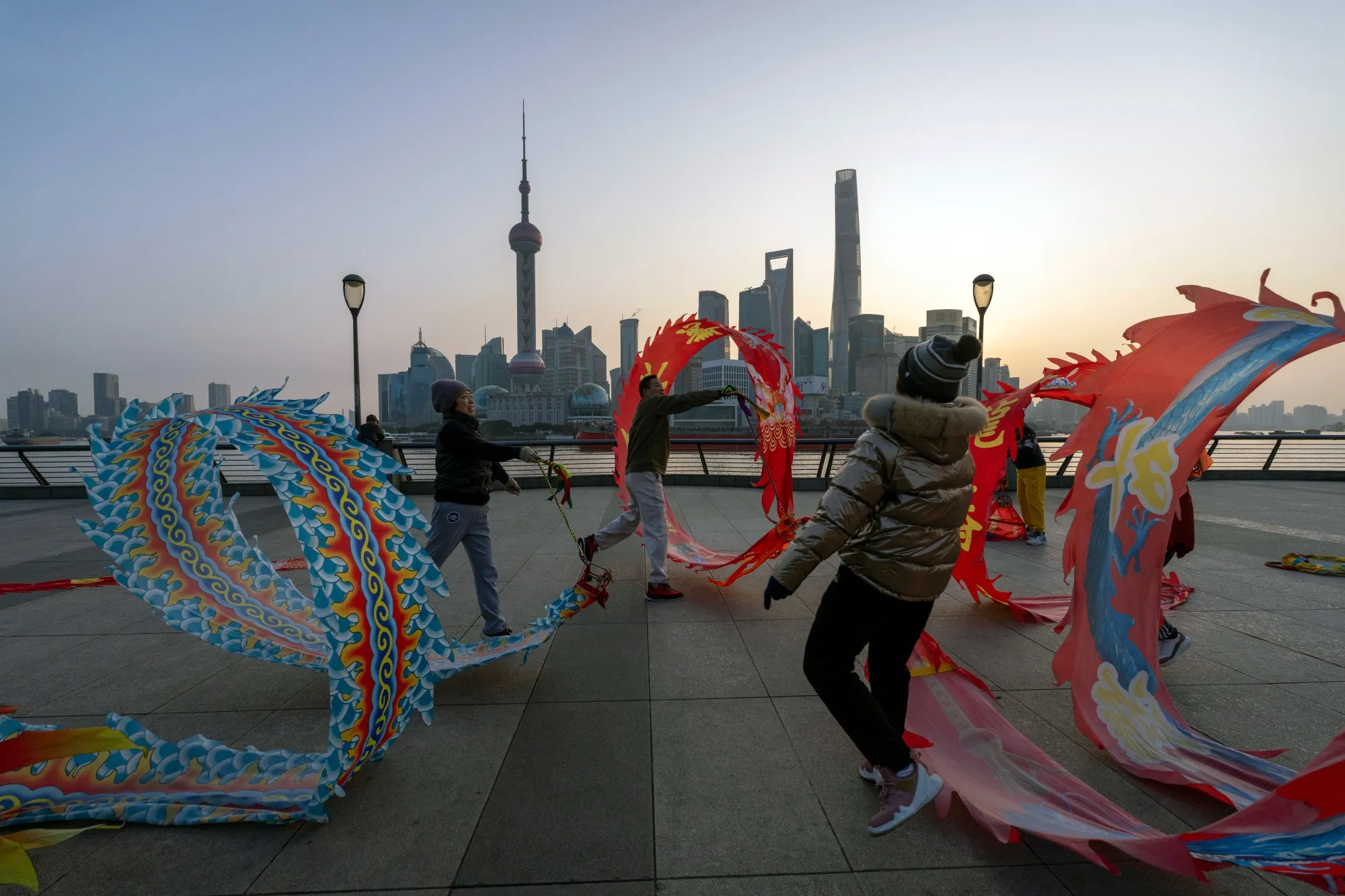 People fly kites along the Bund across from buildings in Pudong's Lujiazui financial district in Shanghai, on Jan. 6.
