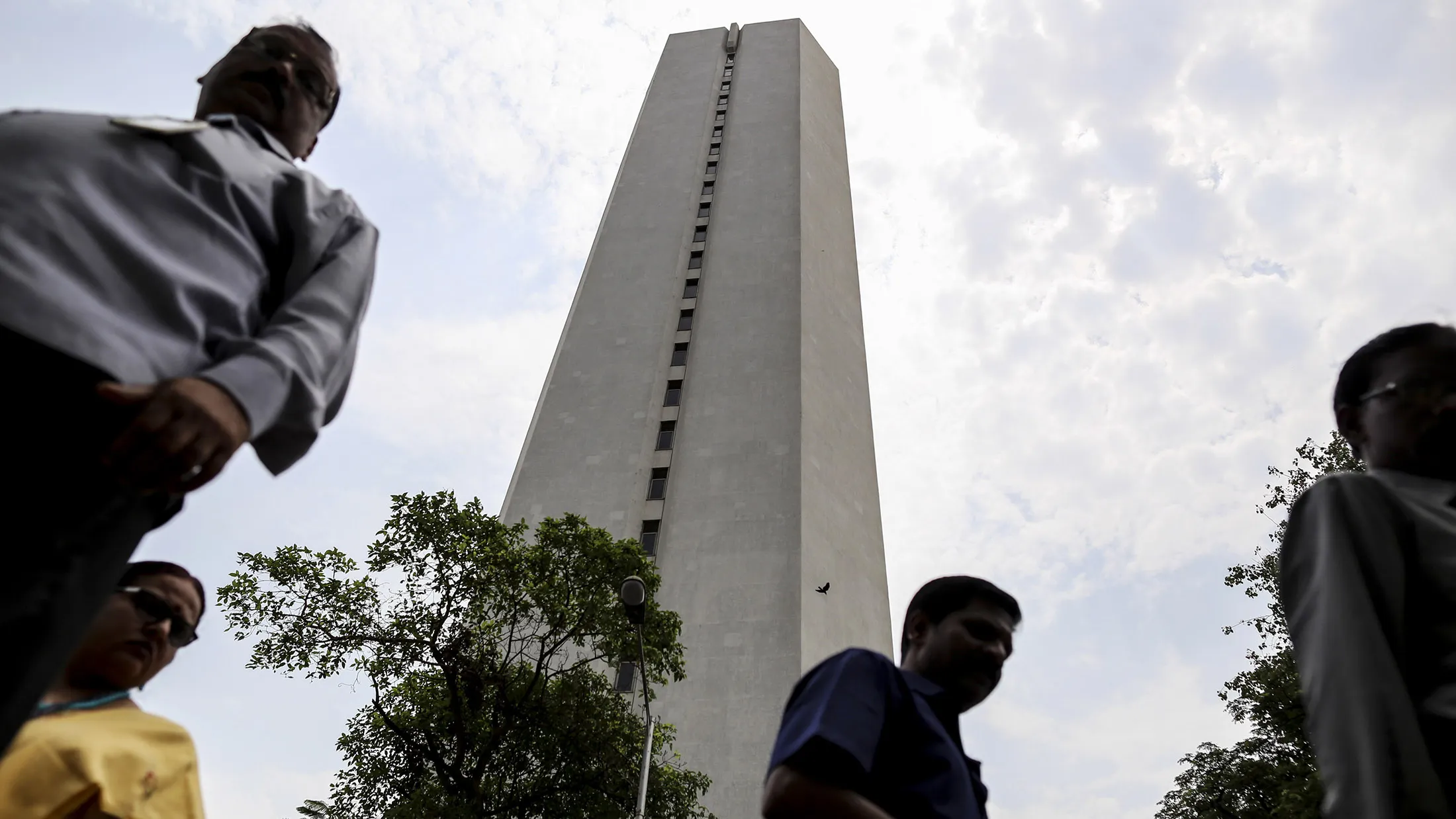 Pedestrians walk past the Reserve Bank of India (RBI) headquarters in Mumbai, India, on Tuesday, April 5, 2016. India's central bank lowered its key interest rate for the first time in six months and said it would look for more room to ease as it watches monsoon rains.
