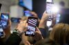 Attendees use mobile devices to take photographs of Pinterest Inc. executives ringing the opening bell on the floor of New York Stock Exchange (NYSE) during the company's initial public offering (IPO) in New York, U.S., on Thursday, April 18, 2019. Pinterest's message to investors was don't compare us to social media or a search engine. The outcome Wednesday was that it raised about $1.4 billion in an above-range initial public offering.