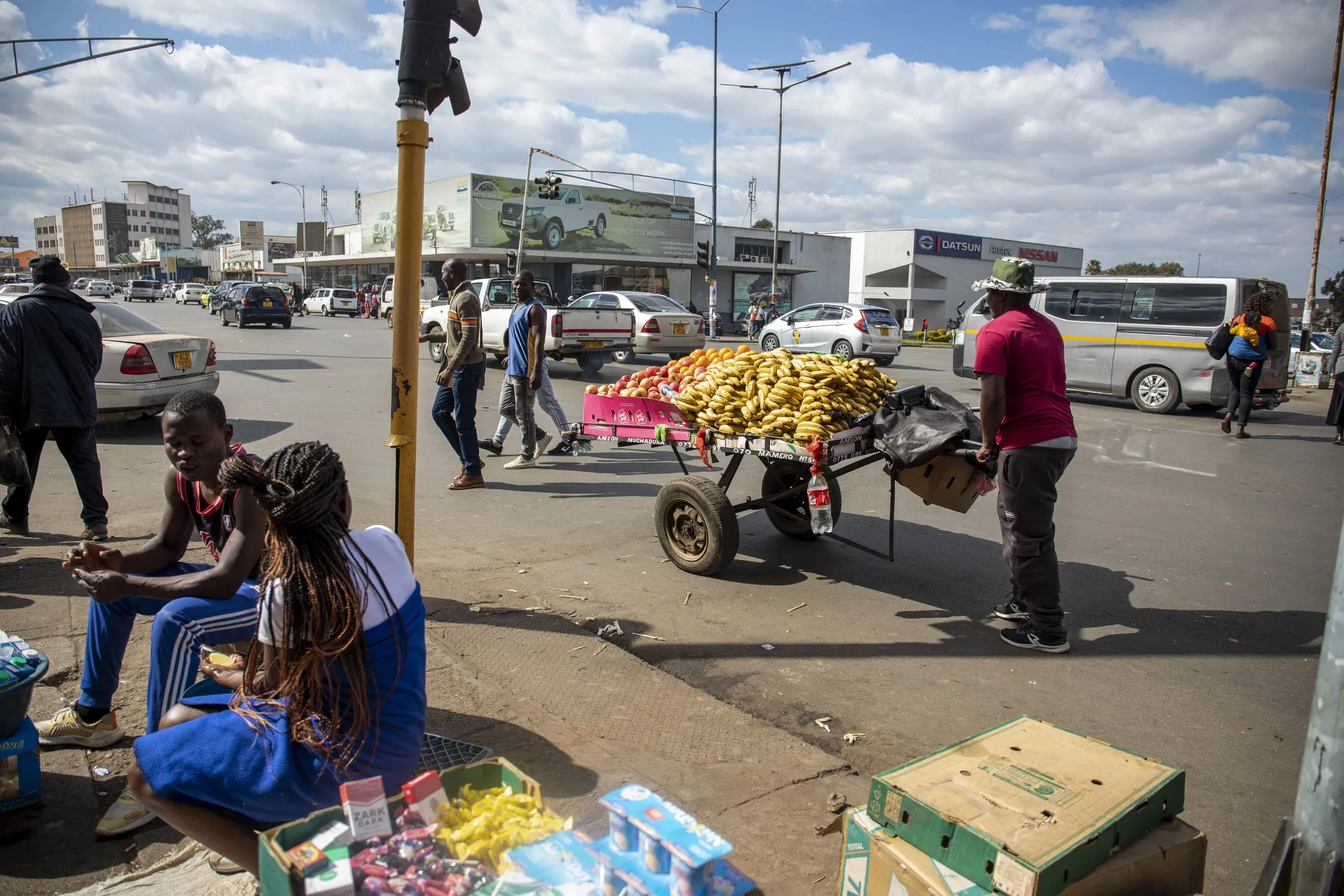 A street vendor pushes a cart of bananas to sell at the bus terminus in the central business district of Harare, Zimbabwe.
