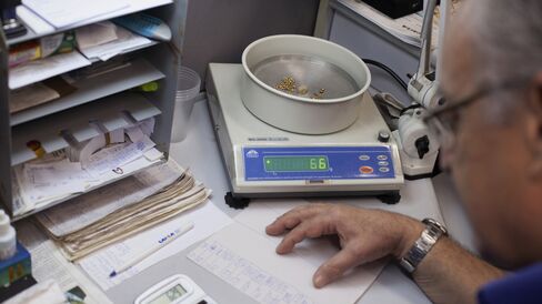Carlos Monteiro weighs a customer's gold jewelry at a government-run pawnshop.
