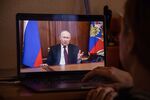 A resident watches a live broadcast of Vladimir Putin, Russia's President, as he delivers an address, on a laptop computer in Moscow, Russia, on Monday, Feb. 22, 2022. 