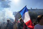 A protester waves a French flag during an anti-austerity demonstration in Paris, France, on Thursday, Sept. 18, 2025. French unions are leading widespread anti-austerity protests Thursday, raising the pressure on newly appointed Prime Minister Sebastien Lecornu as he struggles to find allies to piece together a budget.