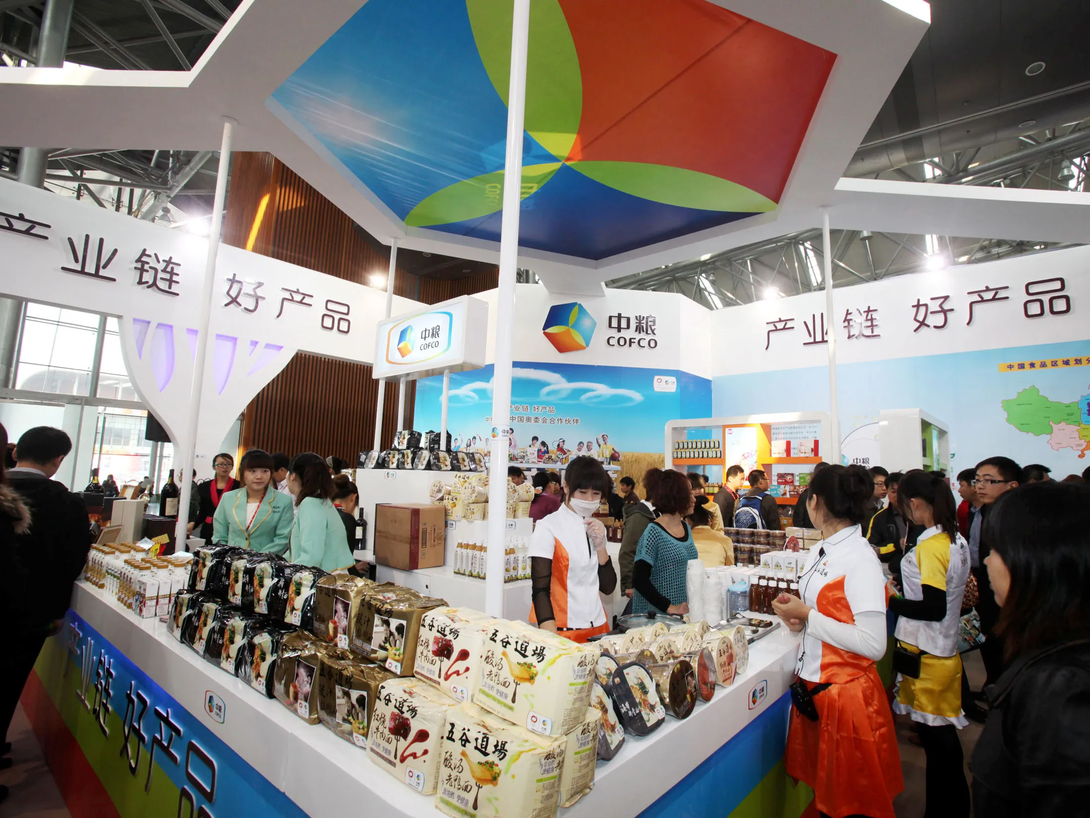 People visit a COFCO stand during an exhibition in Tianjin, China.

