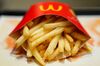 A packet of french fries sit on a tray in this arranged photograph at a McDonald\'s restaurant.