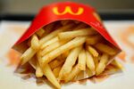 A packet of french fries sit on a tray in this arranged photograph at a McDonald\'s restaurant.