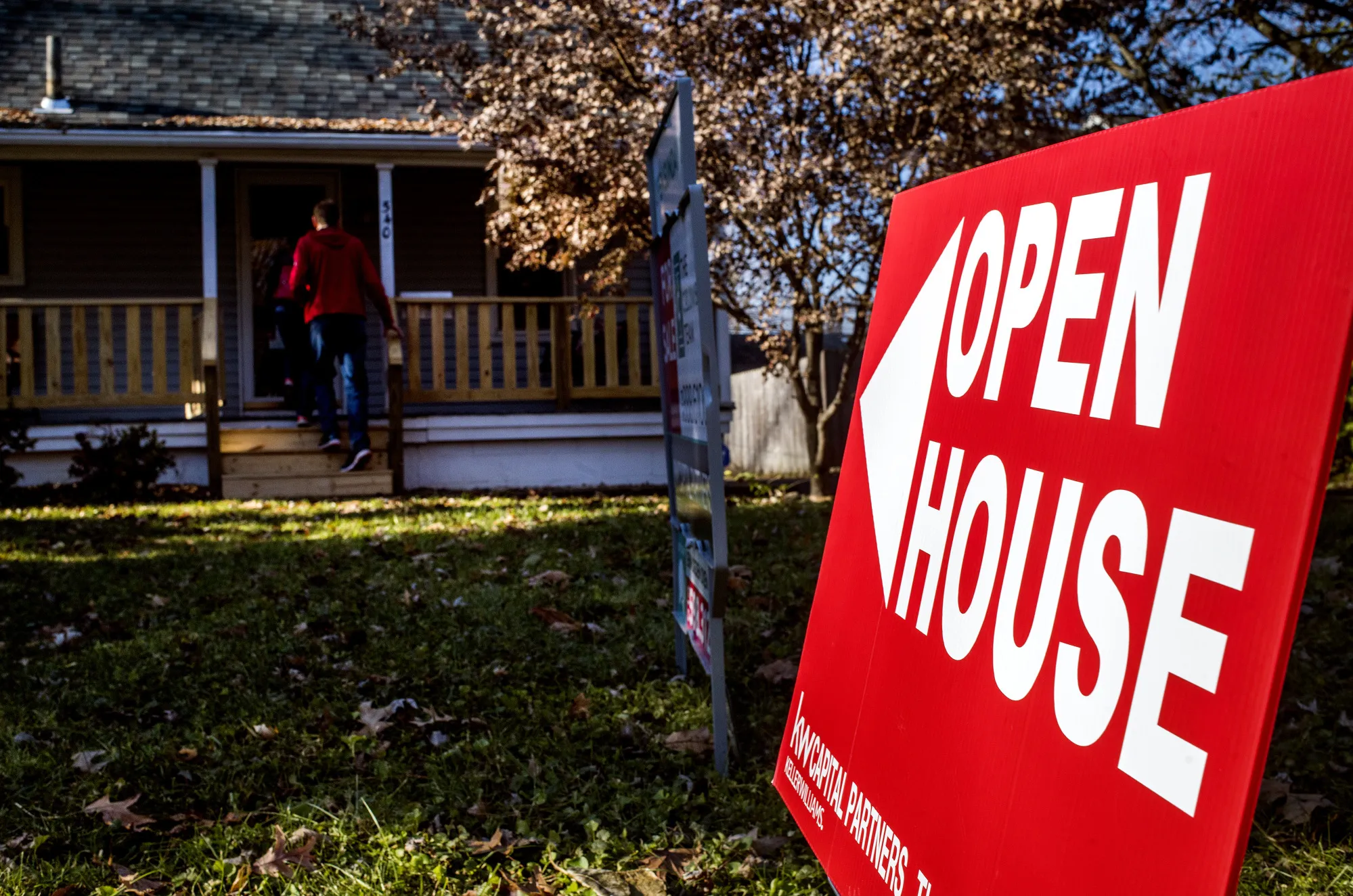 An "Open House" sign is displayed as potential home buyers arrive at a property for sale in Columbus, Ohio.