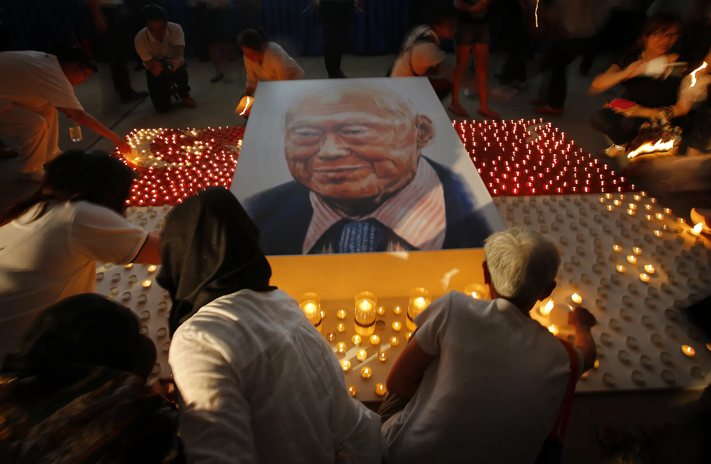 Members of the public light candles around a portrait of the late Lee Kuan Yew as a tribute to him, Friday, March 27, 2015, in Singapore.
