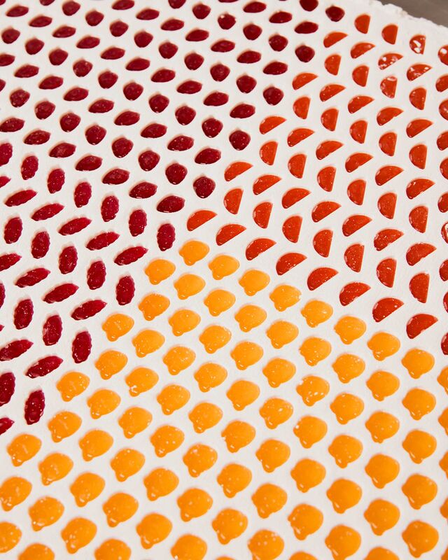 A quality control auditor shows her work before the marked-up leather is cut.