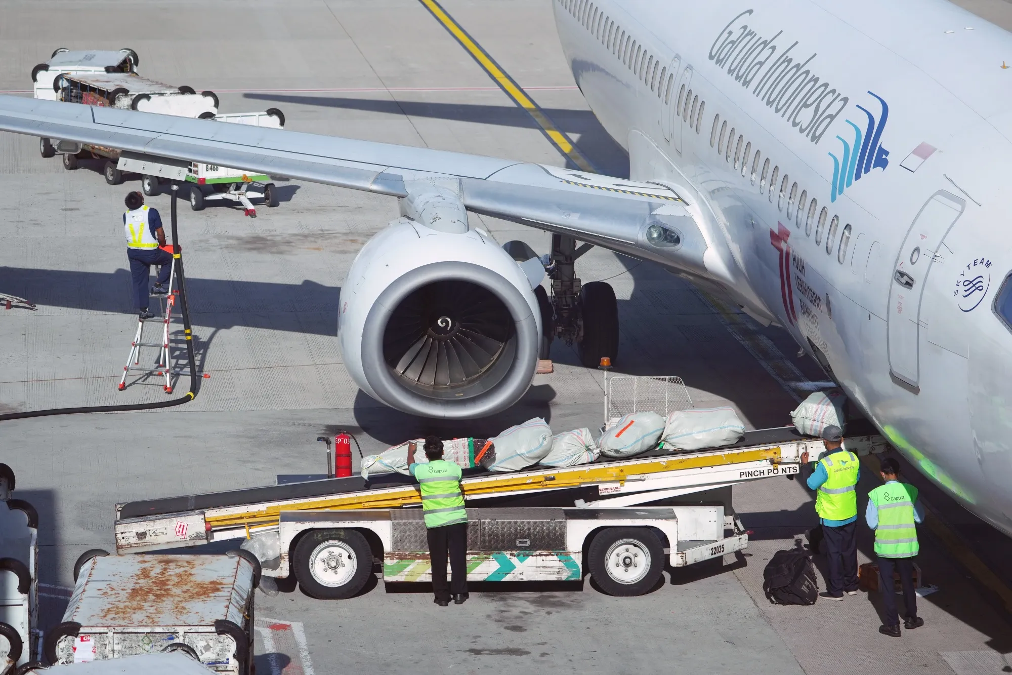 Ground crew load luggage onto Garuda Indonesia flight at Soekarno-Hatta International Airport in Jakarta.