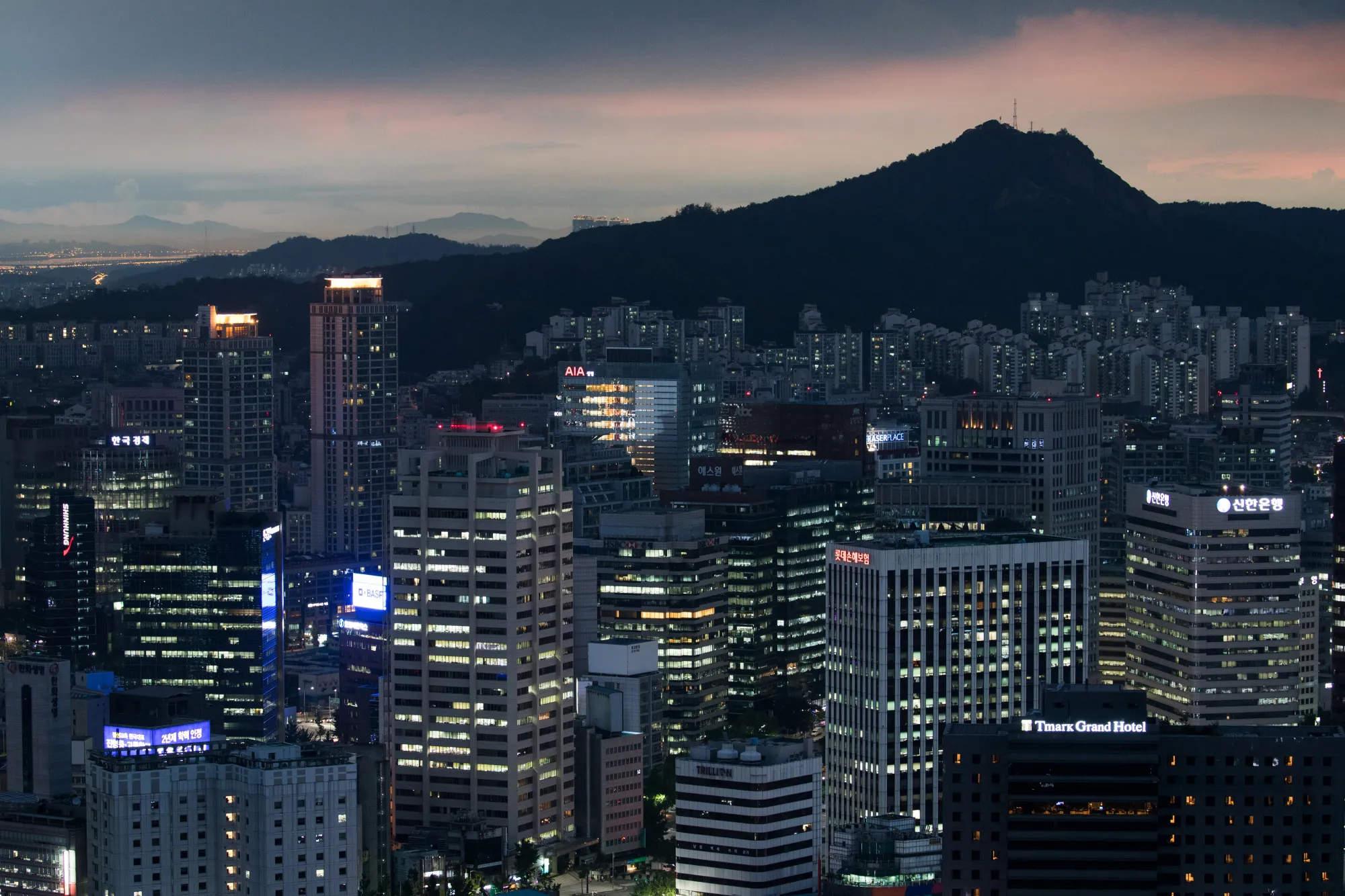 Buildings stand illuminated at night in Seoul, South Korea.