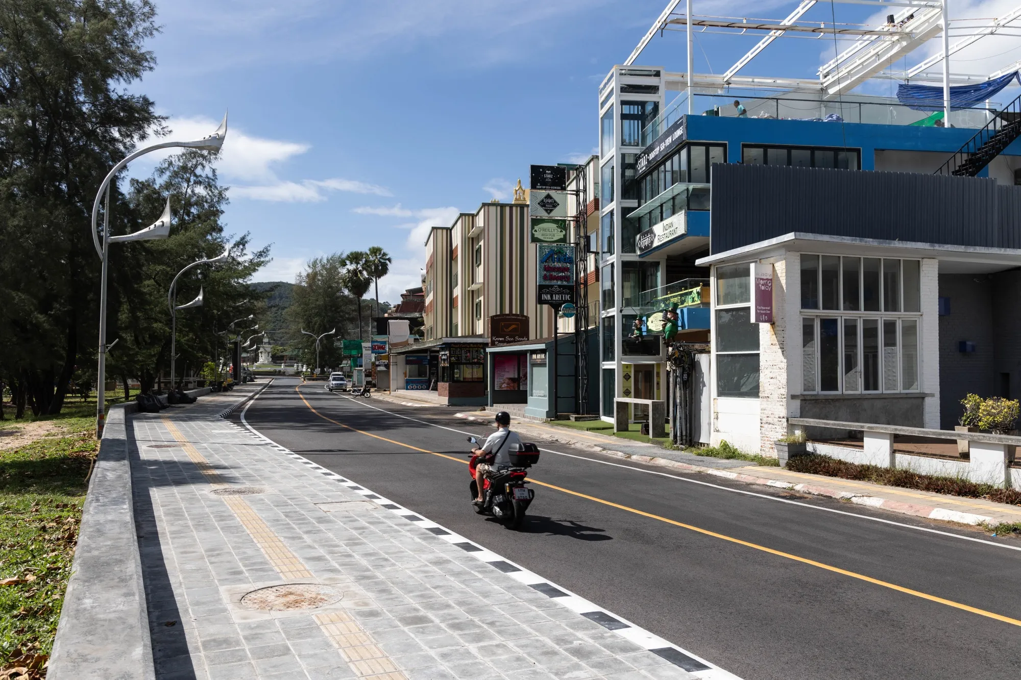 A motorcyclist rides along a deserted road in Phuket, earlier in June.