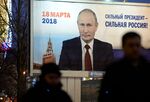 People pass by a billboard with an image of Russian&nbsp;President Vladimir Putin with&nbsp;lettering &quot;Strong president - Strong Russia&quot; in Saint Petersburg on Jan.&nbsp;12, 2018.&nbsp;