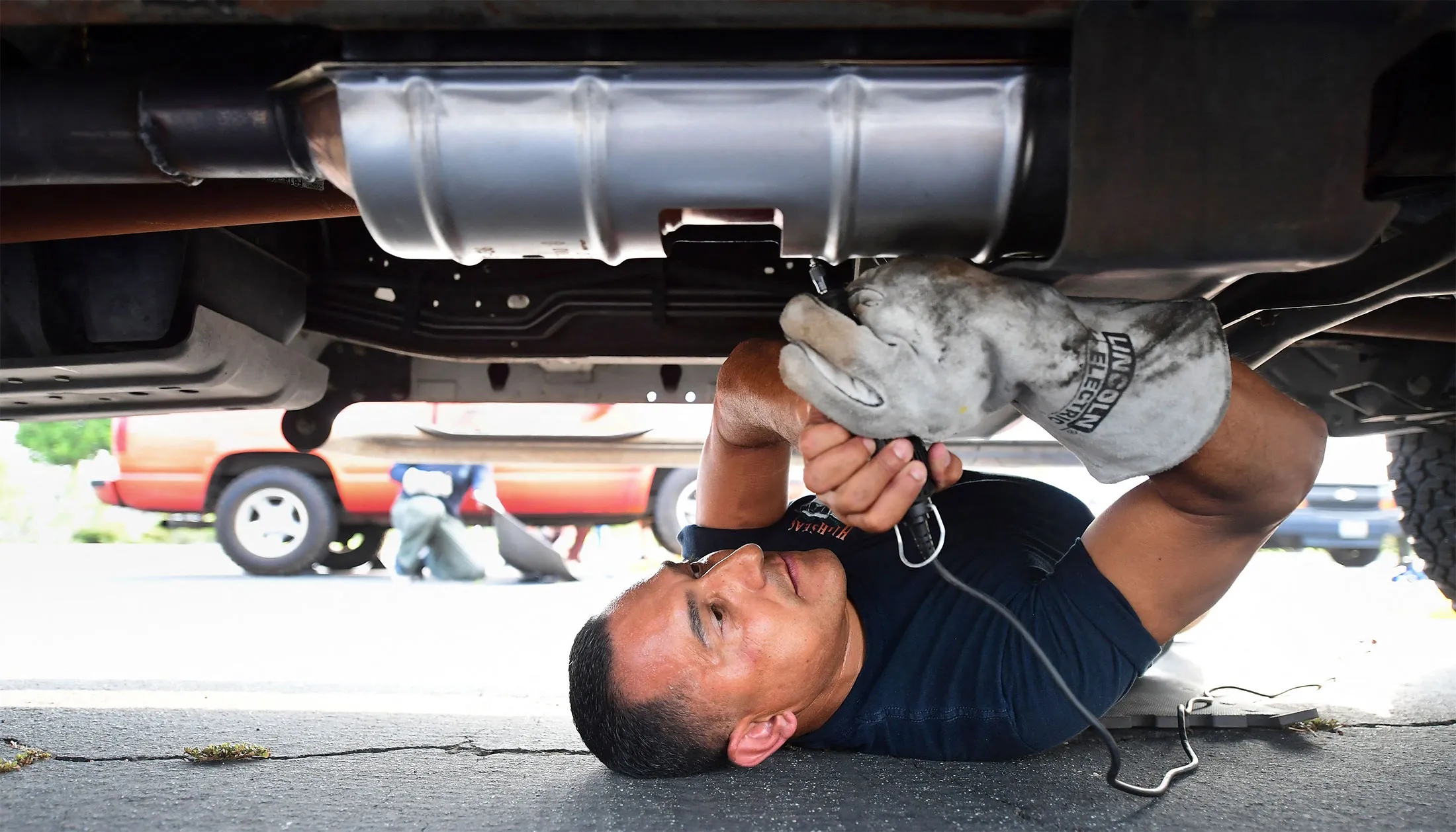A deputy from the Los Angeles Sheriffs Department engraves the catalytic converter of a vehicle with a traceable number in City of Industry, California.