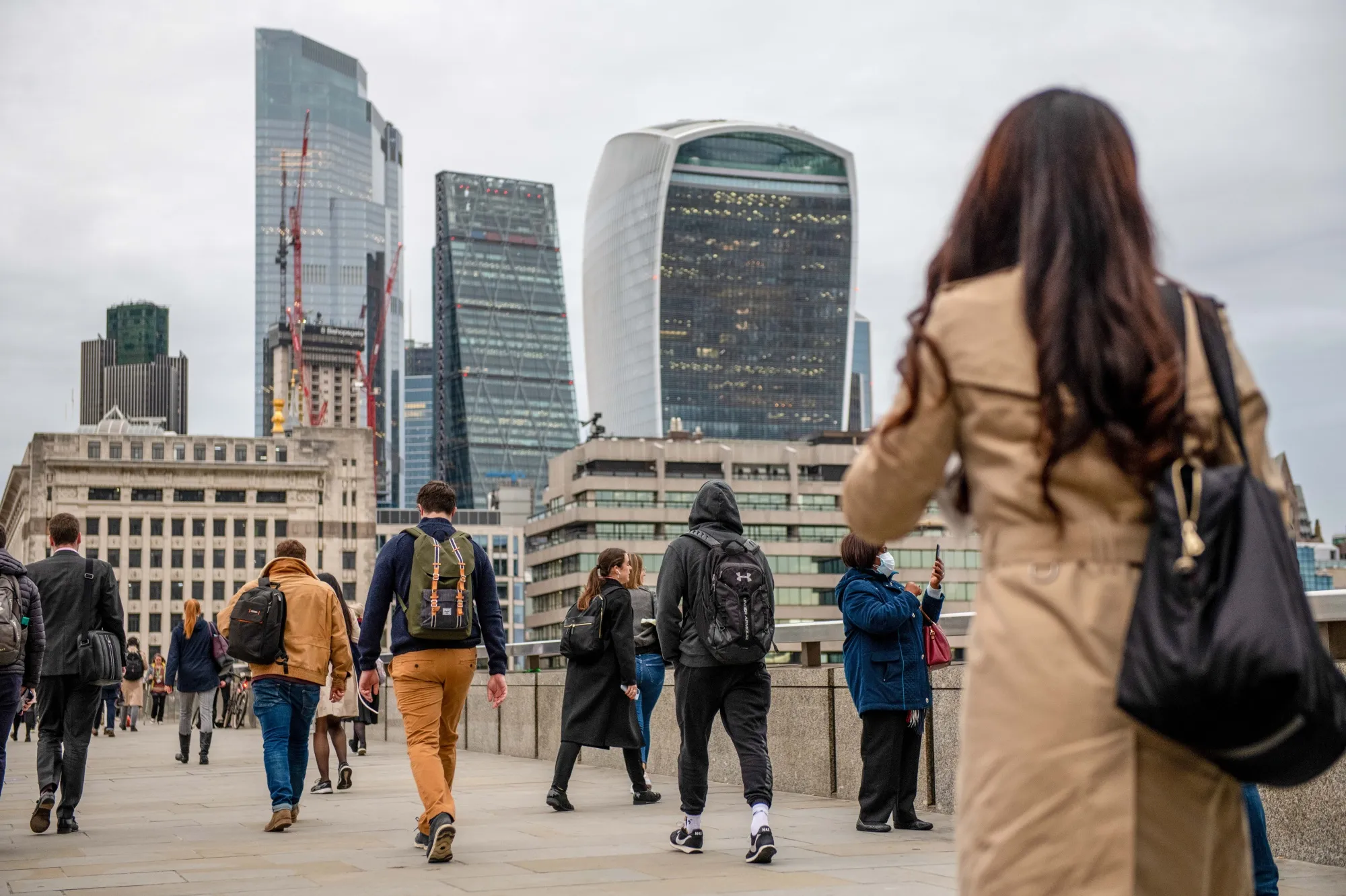 Commuters make their way over London Bridge in London.