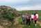 A bike tour guide explains the tiered system of Burgundy wine classification in a vineyard outside of Pommard. The stone mound is a historic hut used for field workers to relax in the cool shade.