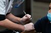 A pharmacist administers a dose of the Pfizer-BioNTech Covid-19 vaccine to a resident of the Triboro Center nursing home in the Bronx borough of New York, U.S., on Monday, Dec. 21, 2020. In the first week since U.S. states started administering Covid-19 vaccines, some states are making more rapid progress than others in working through their allocations from the federal government.