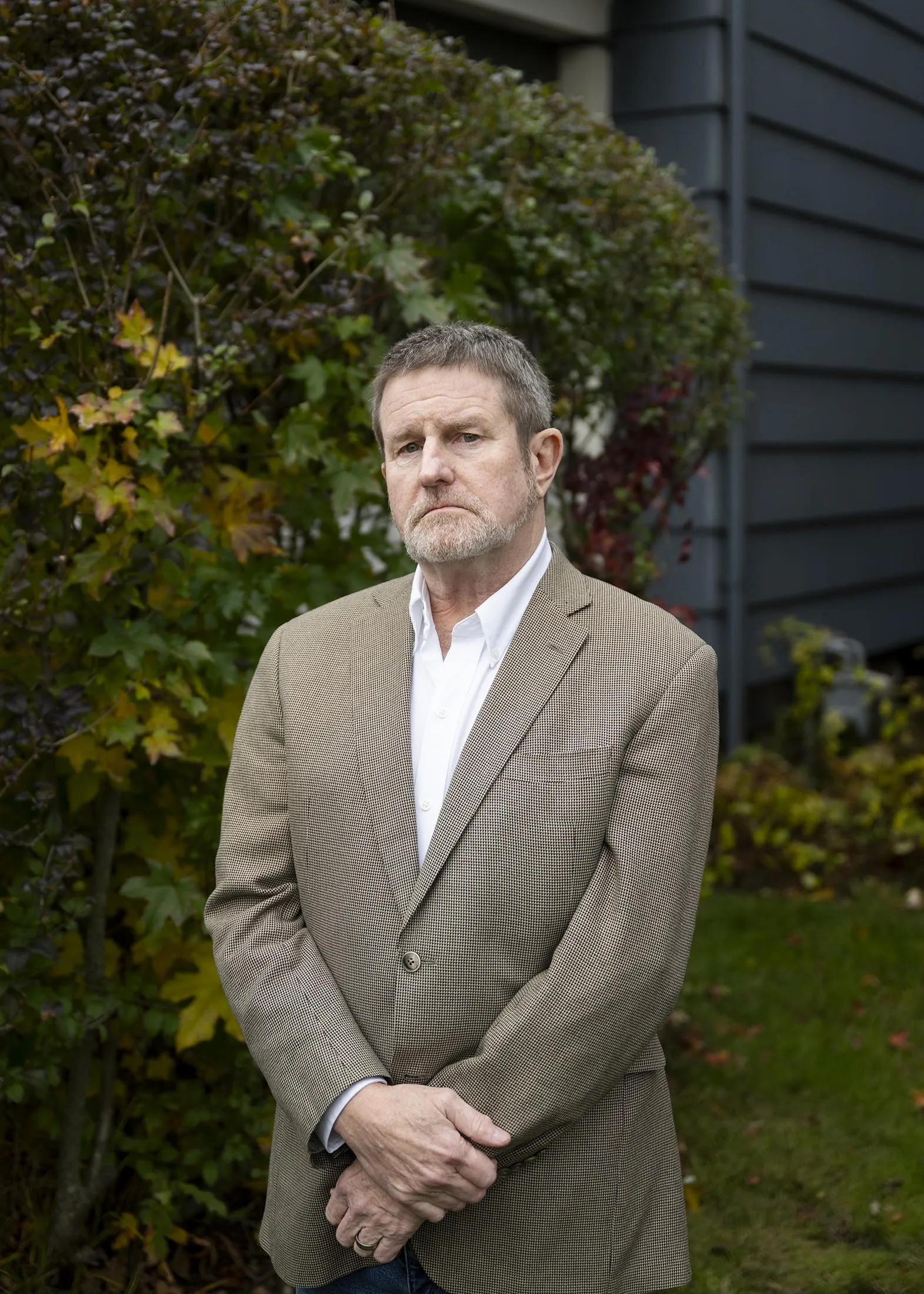 Fraud investigator Tom Gober stands in front of his home