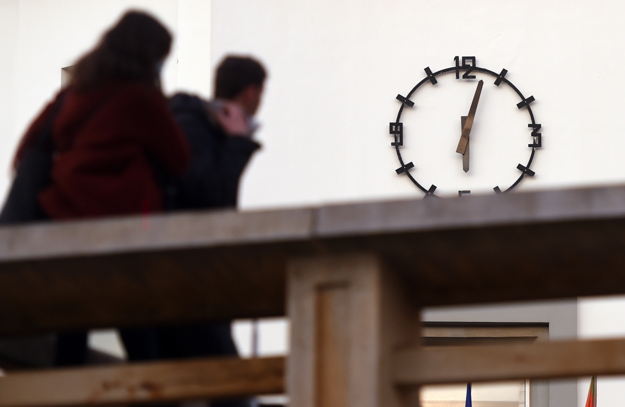 People look at the clock of the city hall in Biarritz, in southwestern France, in January 2021.