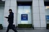 A pedestrian walks past a Mizuho Bank Ltd. and Mizuho Securities Co. branch, units of Mizuho Financial Group Inc., in Tokyo, Japan.