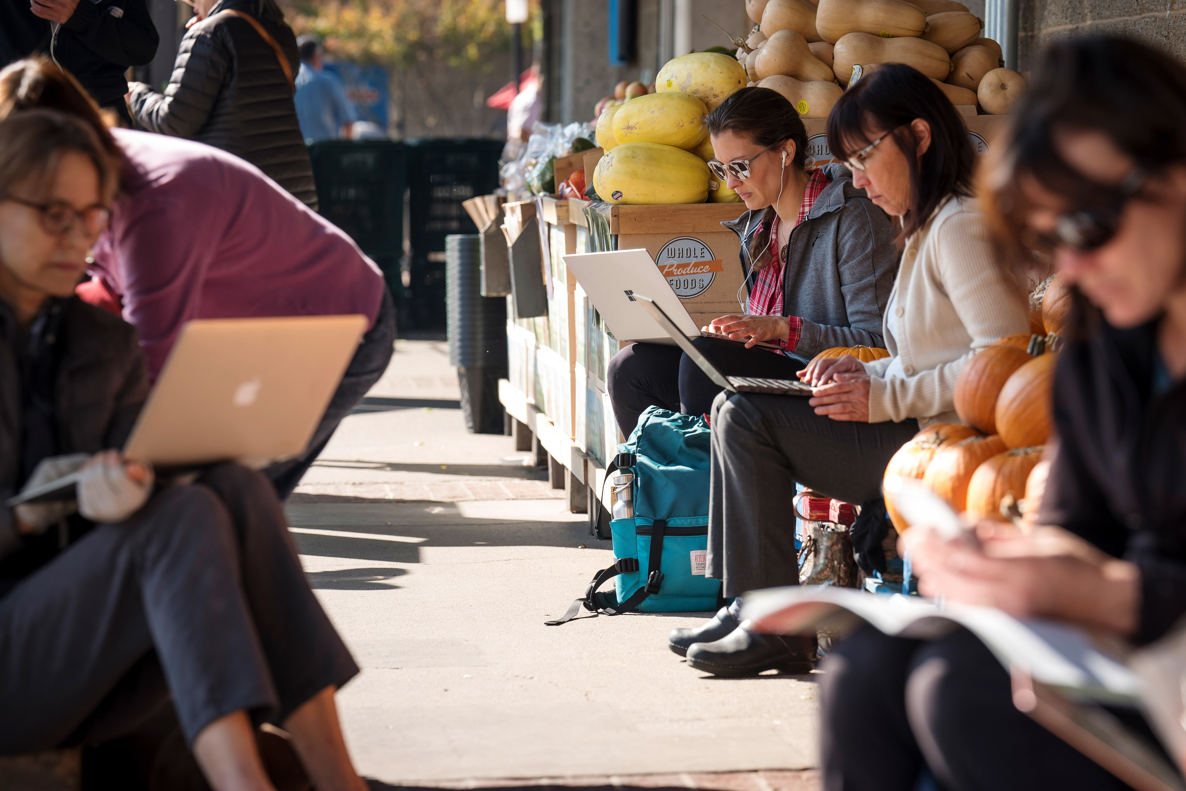 People charge electronic devices and use wifi in front of a Whole Foods in Mill Valley on, Oct. 29.