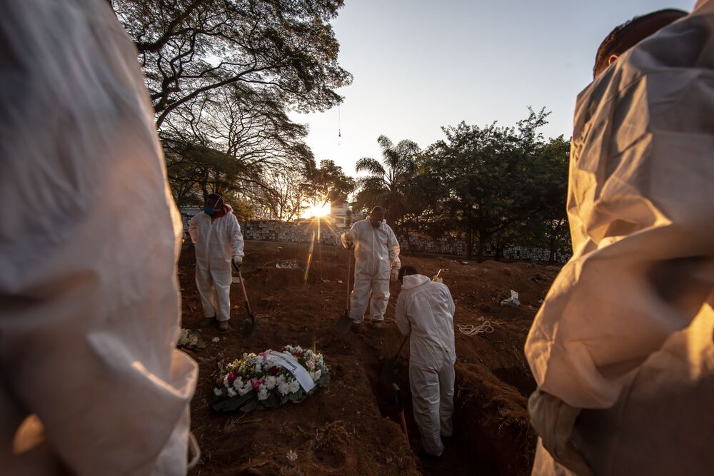 Workers wearing protective equipment prepare to bury the casket of a Covid-19 victim at the Vila Formosa cemetery in Sao Paulo, Brazil.
