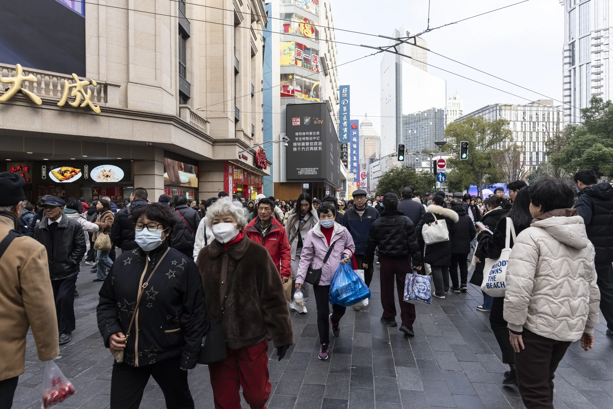 Shoppers walk down Nanjing East Road,&nbsp;in Shanghai.