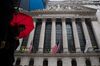Pedestrians carrying umbrellas walk past the New York Stock Exchange (NYSE) in New York, U.S., on Friday, March 2, 2018. U.S. stocks fell, with megacaps bearing the brunt of selling, while Treasuries slipped with the dollar as investors assessed the impact of a potential trade war.