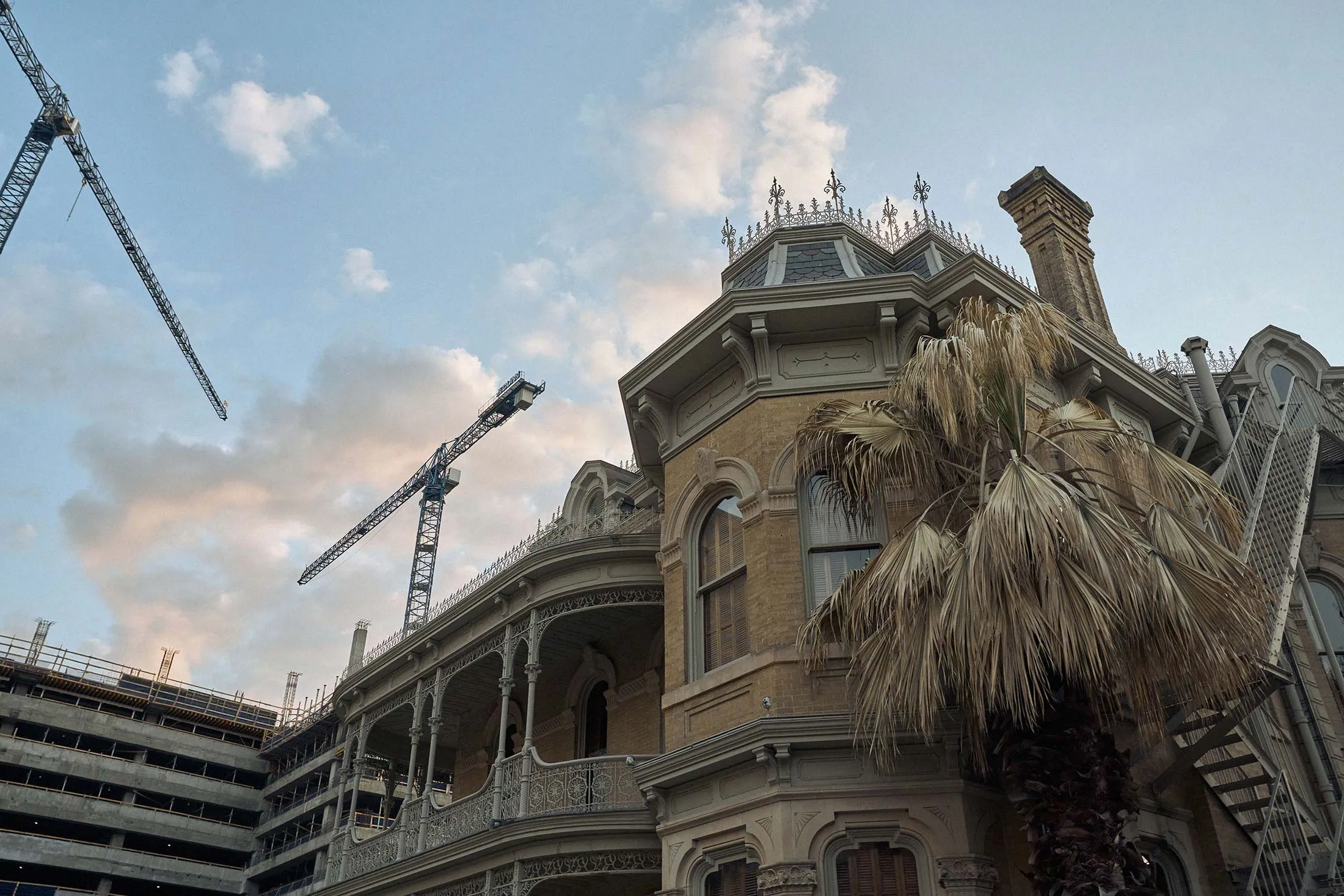 An historical downtown building is surrounded by new construction.