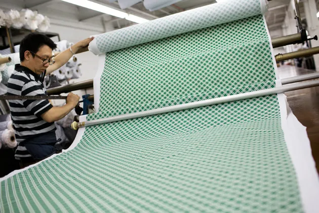 A worker cuts fabric patterns at a garment factory in Brooklyn, N.Y.