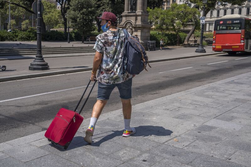 Una persona que lleva una maleta en la estación de Aero Bus con destino