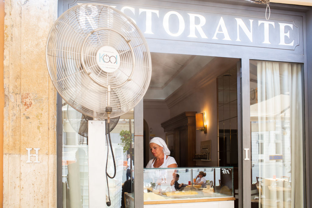 An employee works in a restaurant in the heat in Rome, July 17.