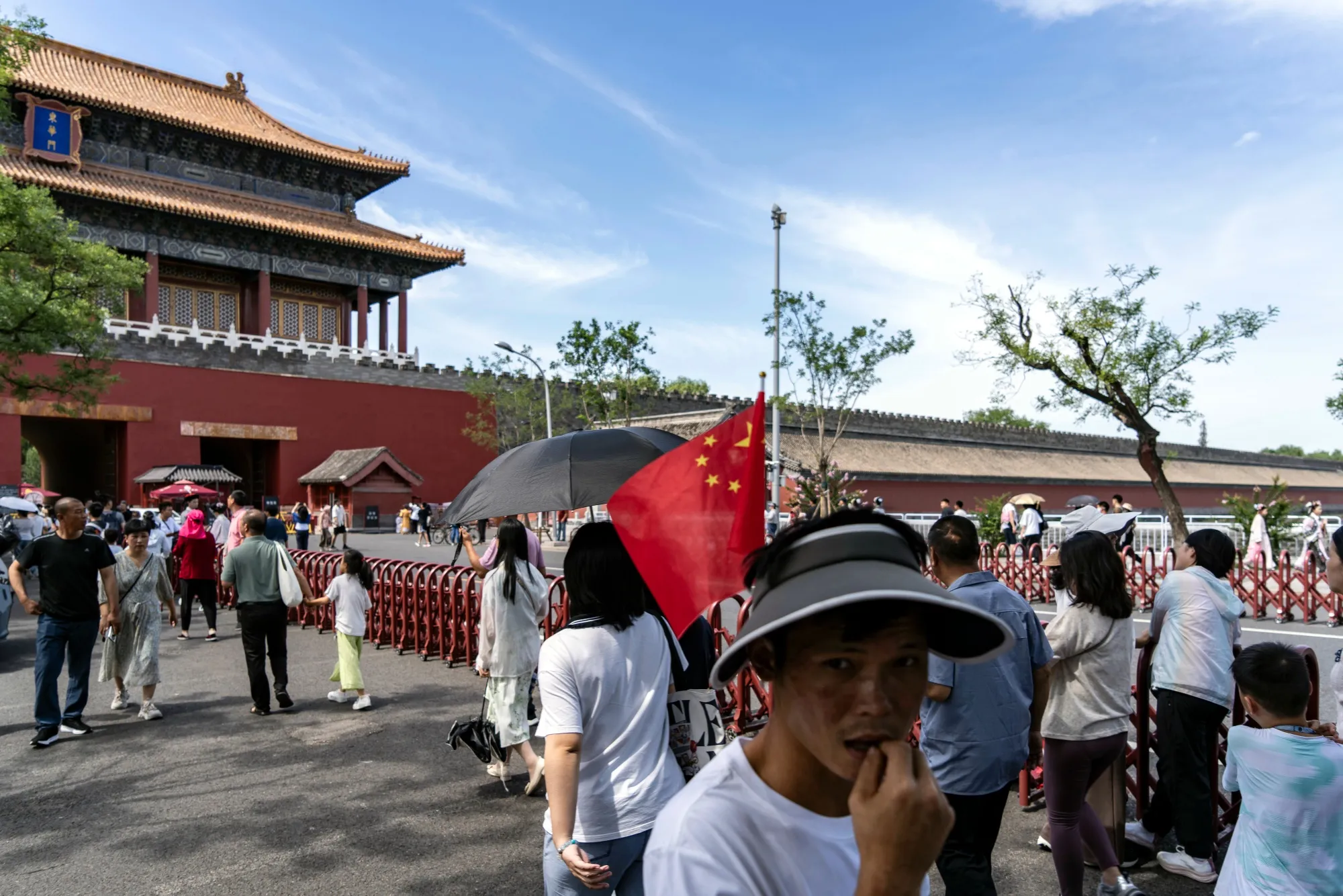 A visitor with a Chinese flag attached to his hat at the Forbidden City in Beijing, China.