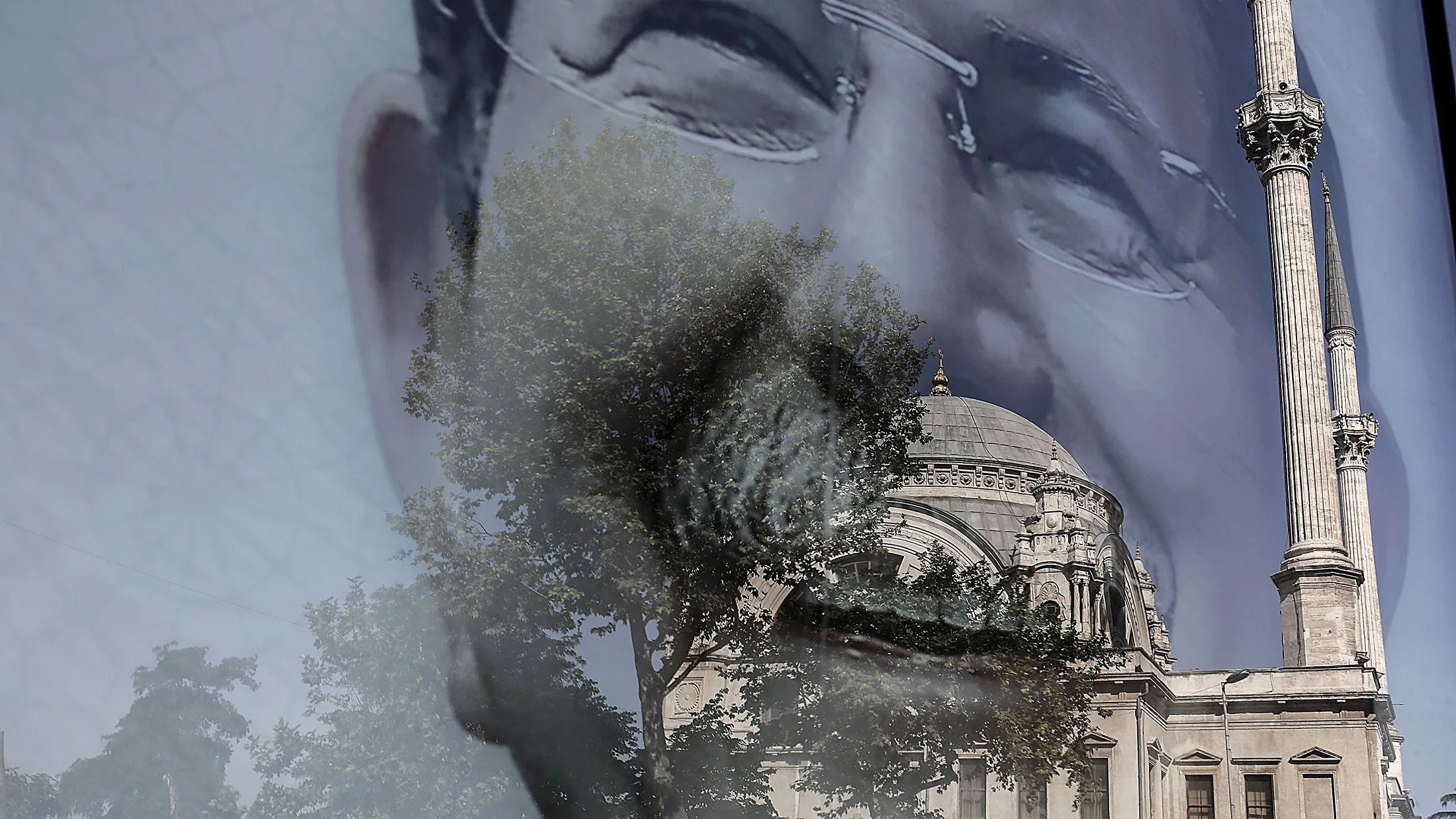 A mosque is reflected in a poster of Turkish Prime Minister Ahmet Davutoglu on June 4, 2015, in Istanbul.
