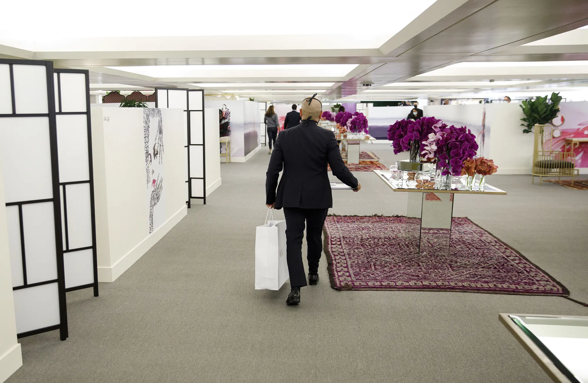 A sales associate carries a shopping bag from an appointment only open-air boutique suite inside The Pavilion at South Coast Plaza in Costa Mesa, California, on Aug. 11.
