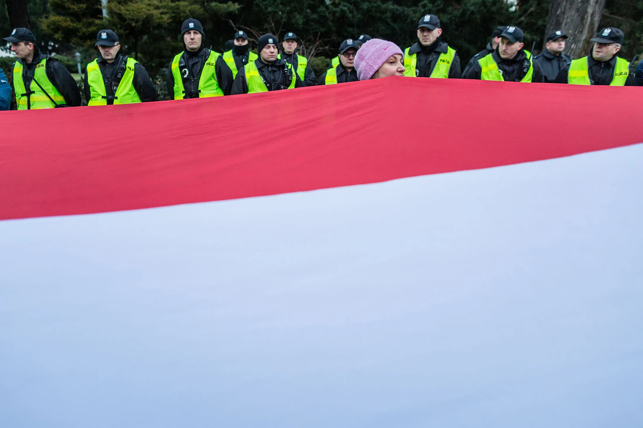 A woman holds a giant Polish national flag as People attend the anti-government demonstration  of opposition parties supporters and Committee for the Defence of Democracy movement (KOD) the day after the parliament crisis in front of building of Polish Parliament, in Warsaw, on December 17, 2016. / AFP / AFP PHOTO / WOJTEK RADWANSKI        (Photo credit should read WOJTEK RADWANSKI/AFP/Getty Images)