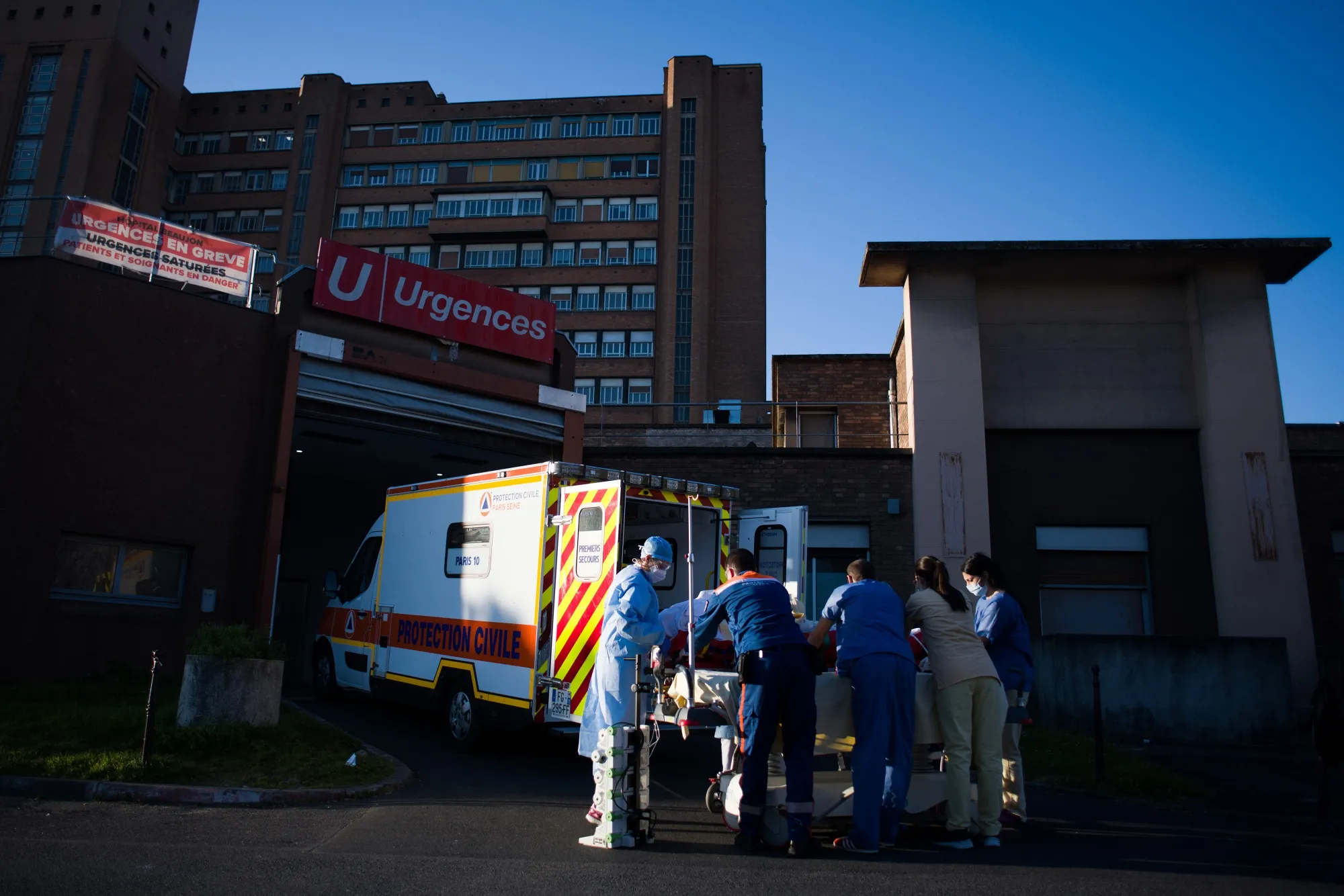 Medical personnel load a coronavirus patient into an ambulance in Paris.