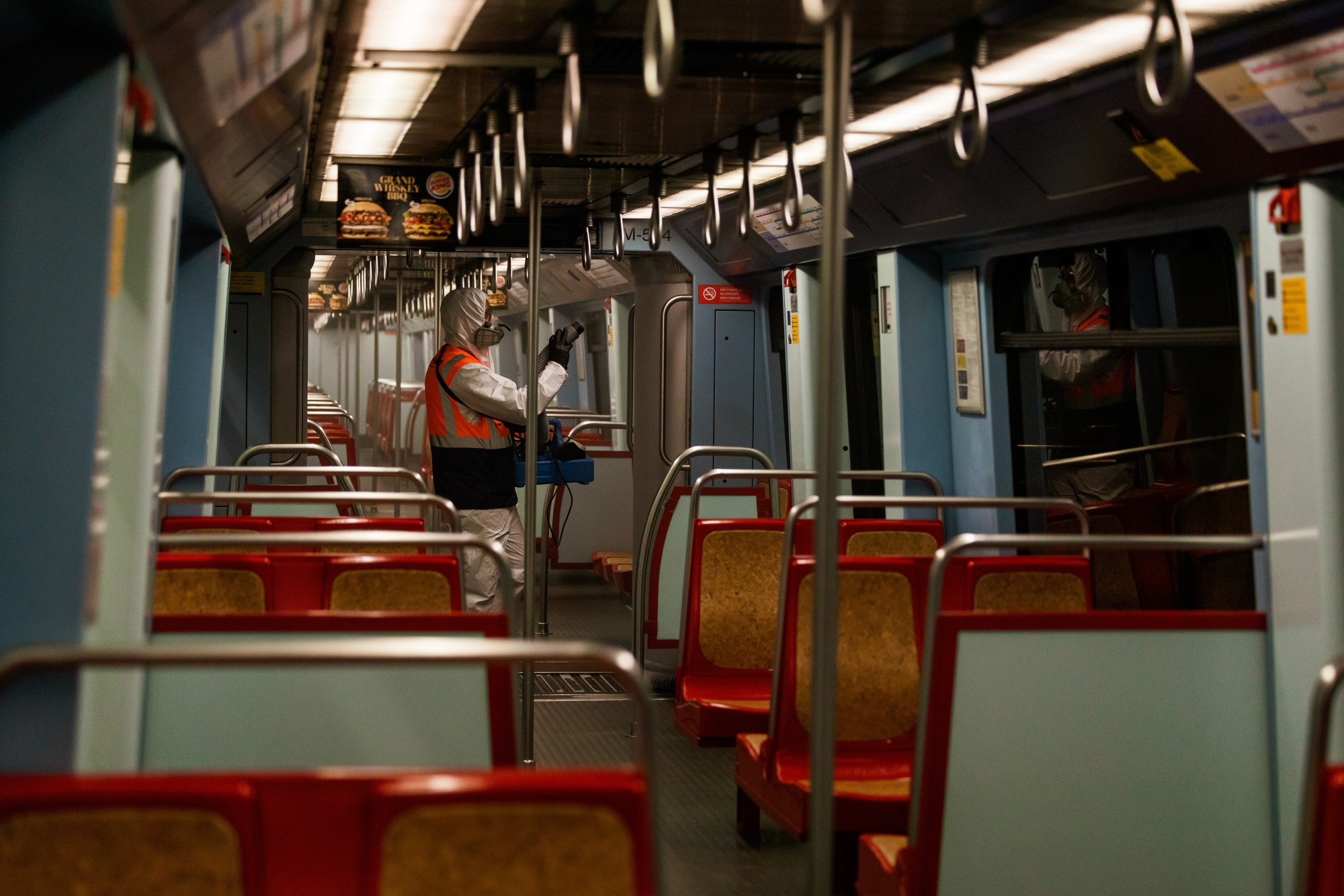 Seorang pekerja kota menyemprotkan desinfektan di bagian dalam gerbong kereta di sebuah stasiun di Lisbon pada 15 April.