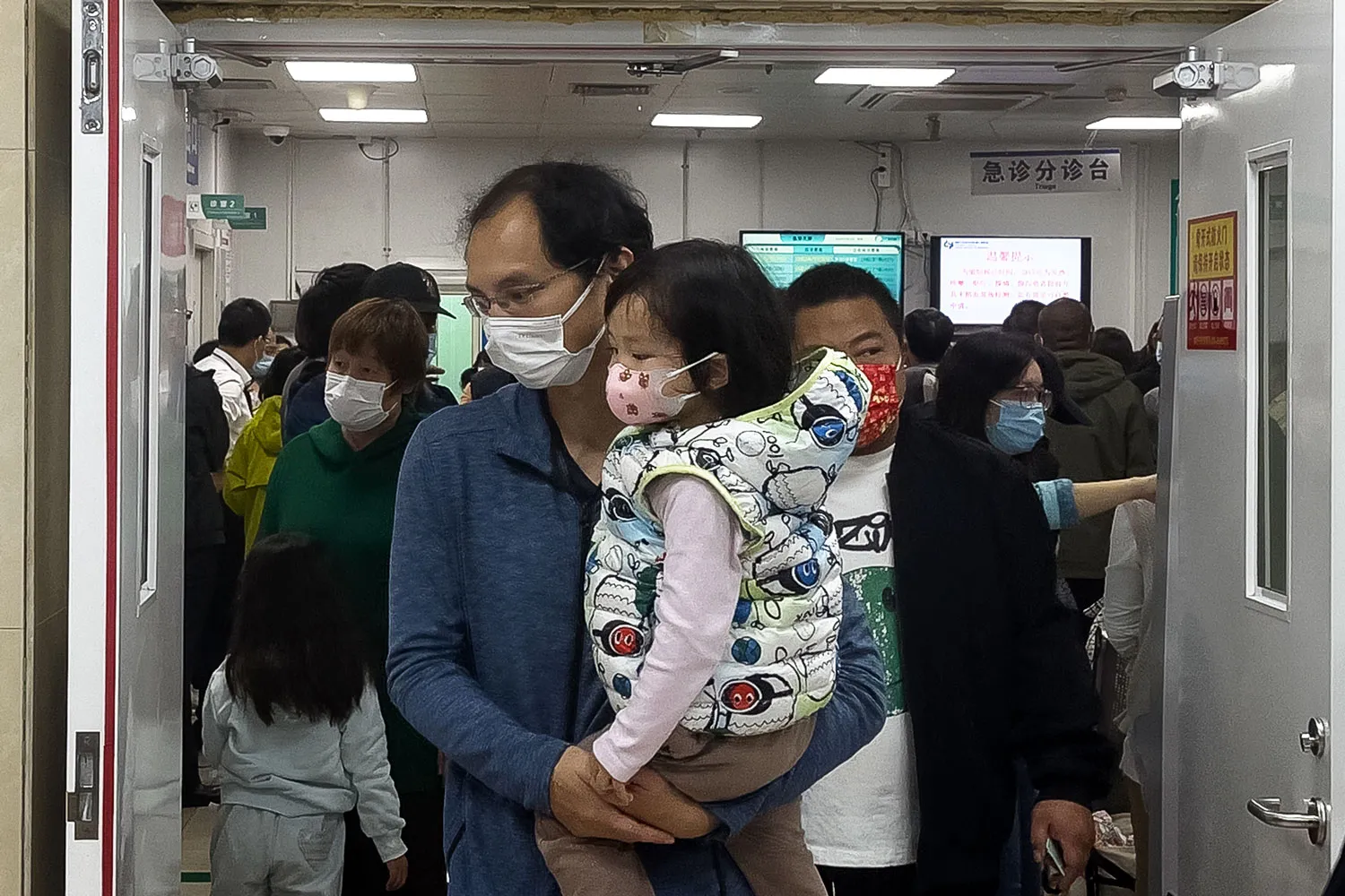 A man carries a child at children's hospital in Beijing on Oct. 30.
